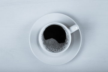 Cup of coffee on blue wooden table. Toned
