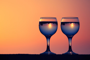 Glasses of white vine with reflections of houses and view to bea