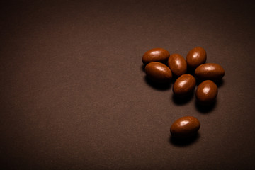 Small chocolate eggs on the black table. Toned