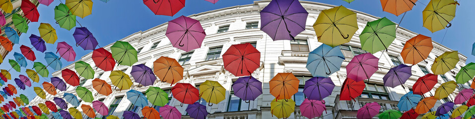 Fototapeta na wymiar Panorama and background with colored umbrellas on one street in Timisoara, Romania