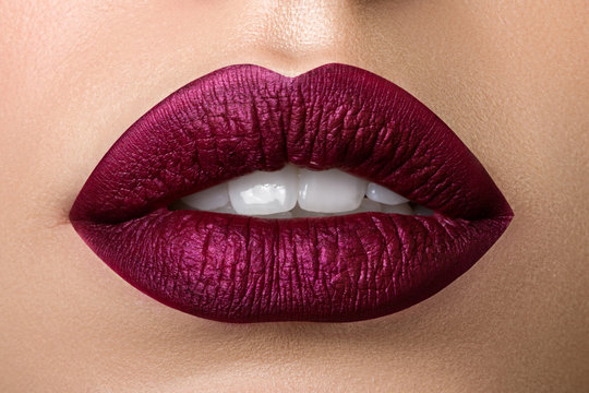 Foto Stock Close up view of beautiful woman lips with purple matt lipstick  | Adobe Stock