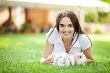 Young girl with two pet rabbit in a park