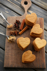 Heart shaped biscuits and cinnamon on cutting board