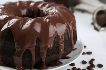 Ring chocolate cake with glaze in plate closeup