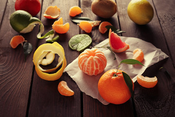 Fresh citrus fruits with green leaves on wooden table closeup