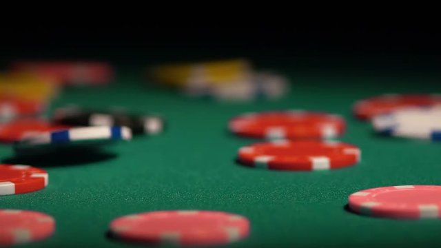 Many poker chips falling on green casino table, gambler winning the super prize