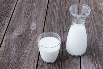 the glass and the bottle of milk on the old table