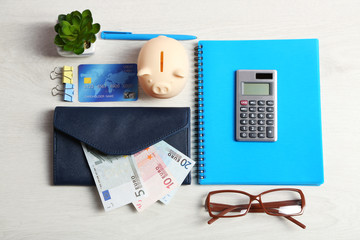 Piggy bank, office supplies and money on a white desk, top view