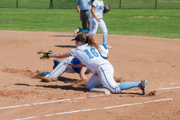 Softball runner and defense player collide at first base. 
