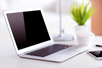 Workplace with laptop and mobile phone indoors