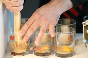 Bartender crushing fruit for cocktails.
