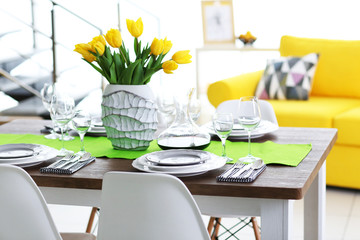 Dining room interior with sofa and table served for dinner