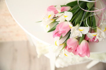 Beautiful bouquet of fresh tulips and irises on wooden table closeup