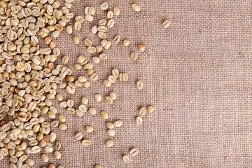 Green coffee beans on sackcloth material.