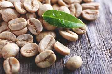 Green coffee beans with a leaf on  wooden table