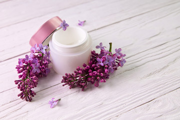 Obraz na płótnie Canvas Pot of moisturizing cream with lilac flowers