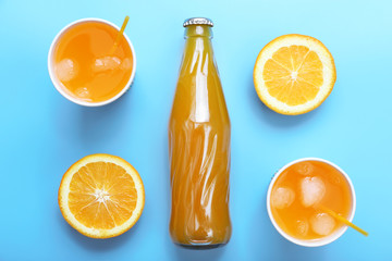Orange drink with ice cubes on blue background