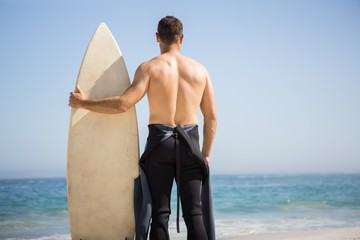 Handsome man holding surfboard