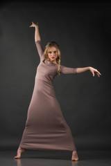 Contemporary dance. Beautiful elegant woman dances on gray background