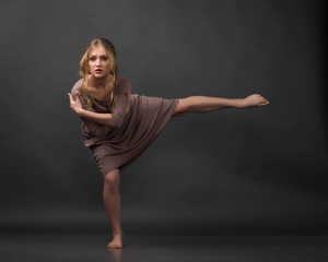 Contemporary dance. Beautiful elegant woman dances on gray background