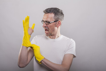Man puts on yellow rubber gloves