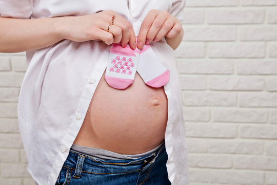 pregnant woman's belly with pink socks