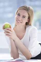 Business woman having healthy snack, eating apple