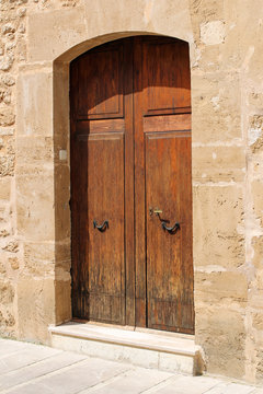 wooden door in stone wall, mediterranean style