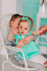 Smiling young brother and little cute todler sister in studio