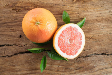 Grapefruit with leaves isolated on wooden background