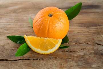 Oranges fruit with leaves on wooden background