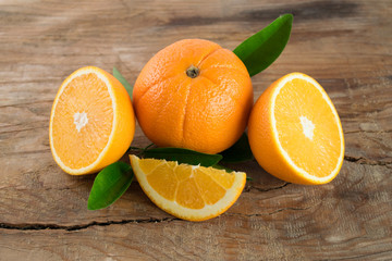 Oranges fruit with leaves on wooden background