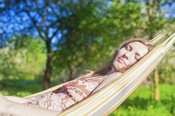 Dreaming Caucasian Blond Woman Resting in Hummock Outdoors.