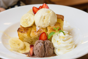 Honey toast and ice cream with strawberries and banana sliced to