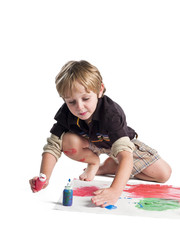 boy doing painting on piece of paper.