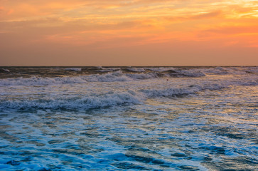 Waves in sunset light, stormy sea. Natural summer background with copy space