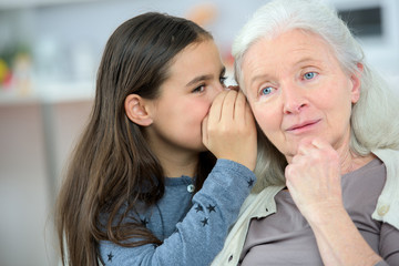 Little girl and grandma whispering secrets