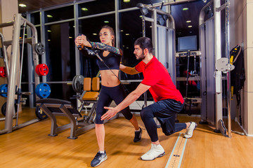 Fototapeta na wymiar fitness, sport, training and people concept - Personal trainer helping woman working with in gym