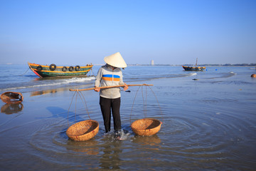 People with conical hat cleaning fish basket, at Long Hai townsh