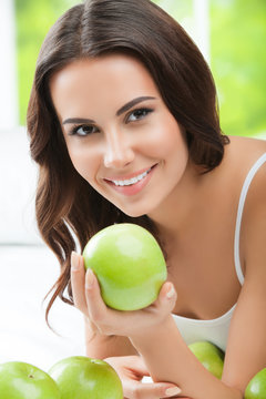 Young smiling woman with green apples