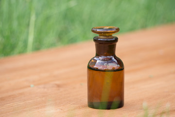 little brown bottle on booden board and grass