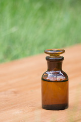 little brown bottle on booden board and grass