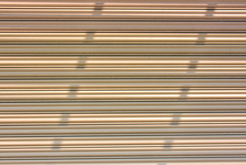 Shade of sun screen on corrugated steel shutter