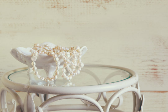 white pearls necklace on vintage table. selective focus