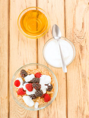 Vertical making breakfast with yogurt and cereals