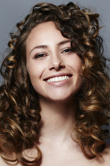 Curly haired beautiful woman, smiling