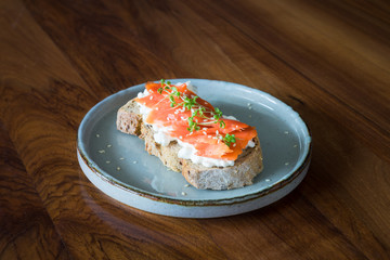 Sandwich with smoked salmon, cottage cheese, garden cress and sesame seeds. Selective focus.