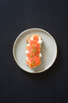 Sandwich with smoked salmon, cottage cheese, garden cress and sesame seeds. Selective focus.