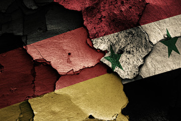 flags of Germany and Syria painted on cracked wall