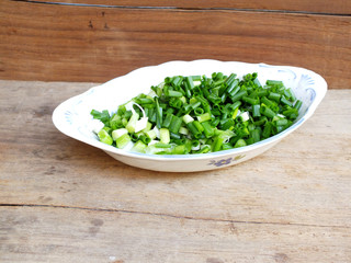 fresh spring onion chopped green onions on wooden background